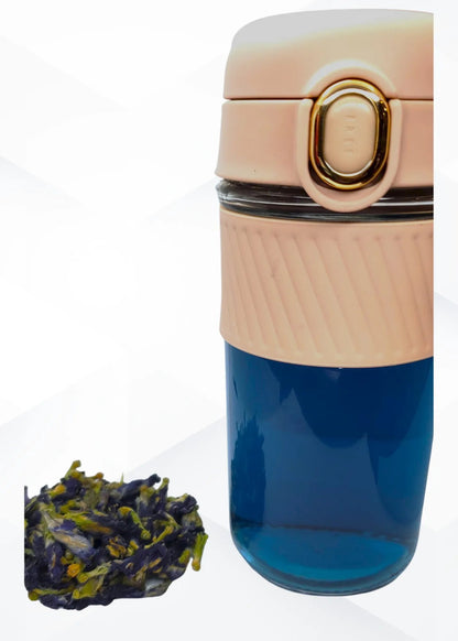 brewed tea showing blue color and beige top, accompanied by loose tea leaves on a white background.